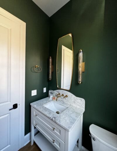 Bold forest green walls paired with marble countertops