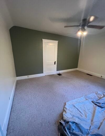 Accent wall in living room painted dark green