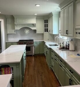 Sage green kitchen cabinets refinished by Bishop Elite Painting